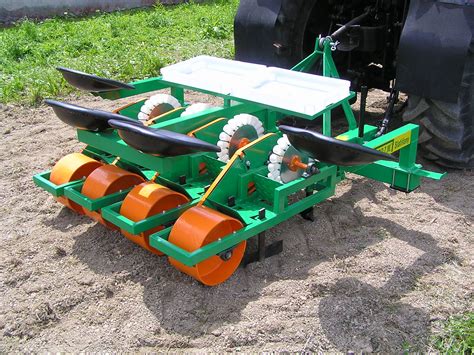 Cutting & Storing The harvester-cutters remove the bulb from the soil, cuts the leaves, and stores the bulbs. . Small scale garlic planter